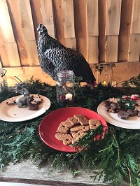 A chicken on a table with cookies.