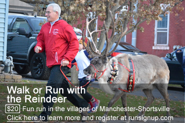Man running down a street leading a reindeer with bells on