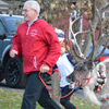 A man leading a reindeer.